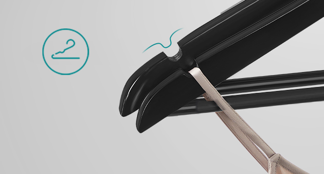 Gros plan d'un outil de coiffure noir avec pince incurvée et lames métalliques, ouvert par une main invisible