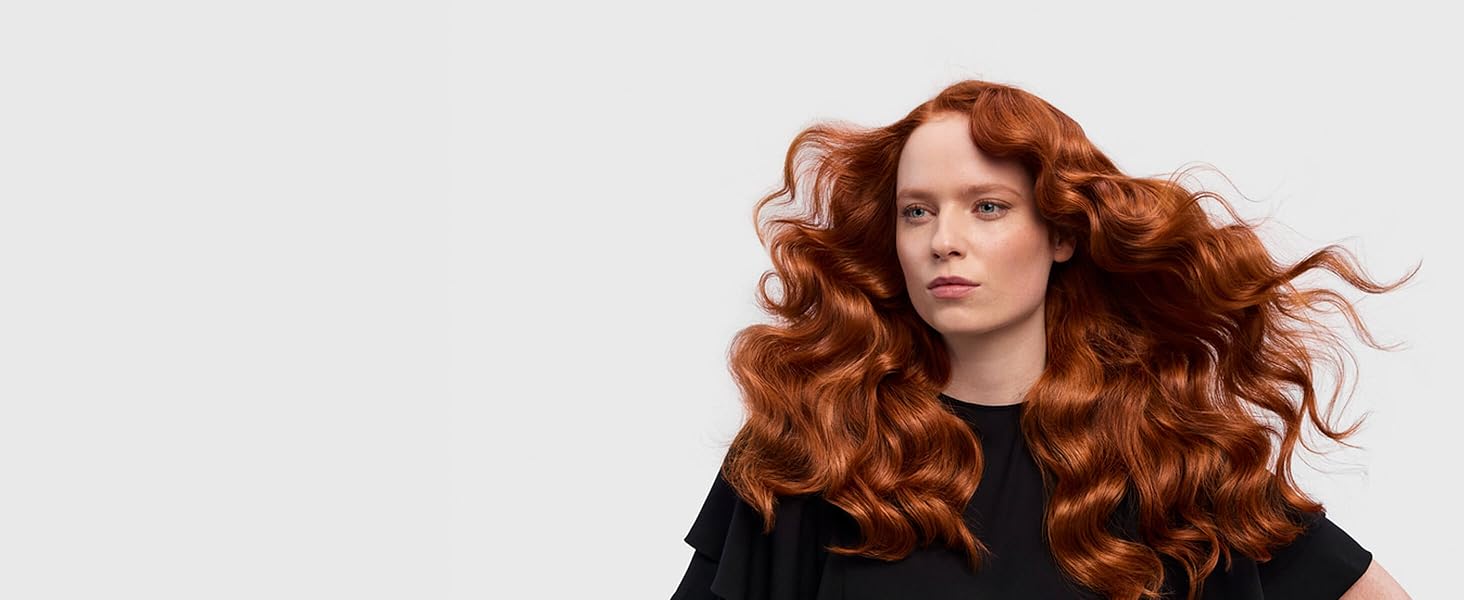 Un mannequin aux cheveux roux avec ses longs cheveux en ondulations rétro.