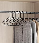 avec plusieurs cintres en plastique noir pouvant contenir des vêtements de couleur claire, mettant en valeur des rangements organisés