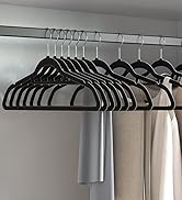 Ensemble de cintres en plastique noir sur une tige métallique. Les cintres présentent un design uniforme avec des épaules arrondies et une barre transversale inférieure pour les pantalons